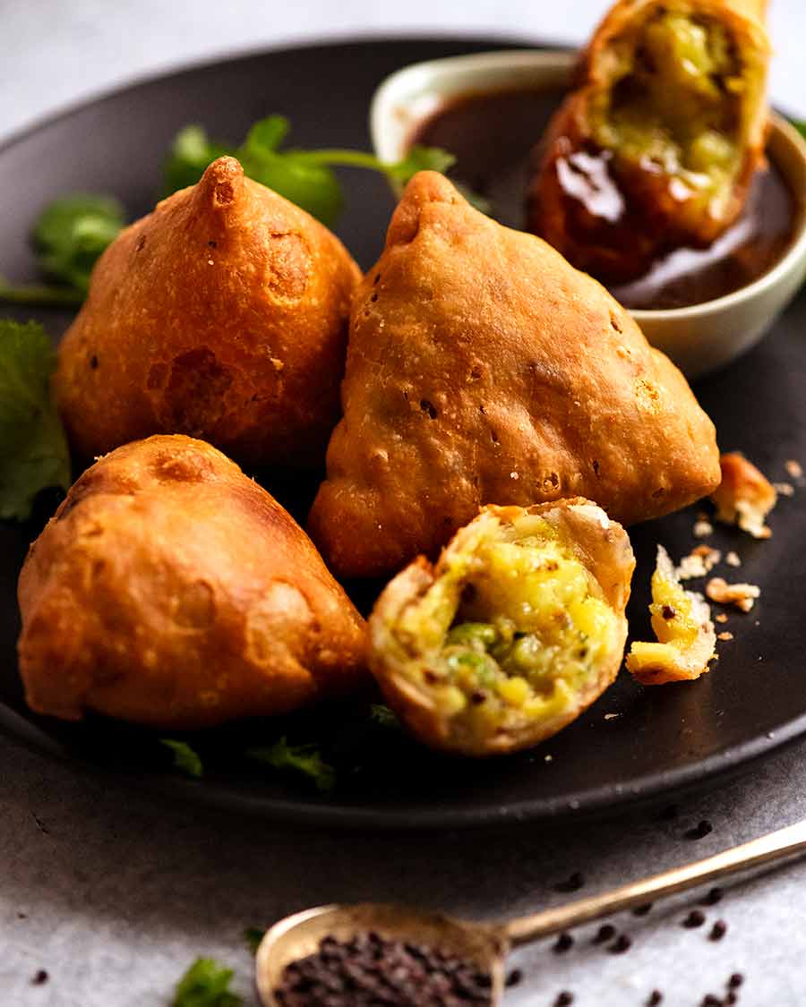Samosas on a plate with tamarind dipping sauce