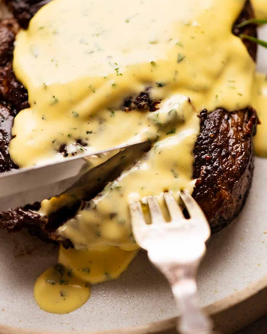 Close up of knife cutting into steak with Bearnaise Sauce