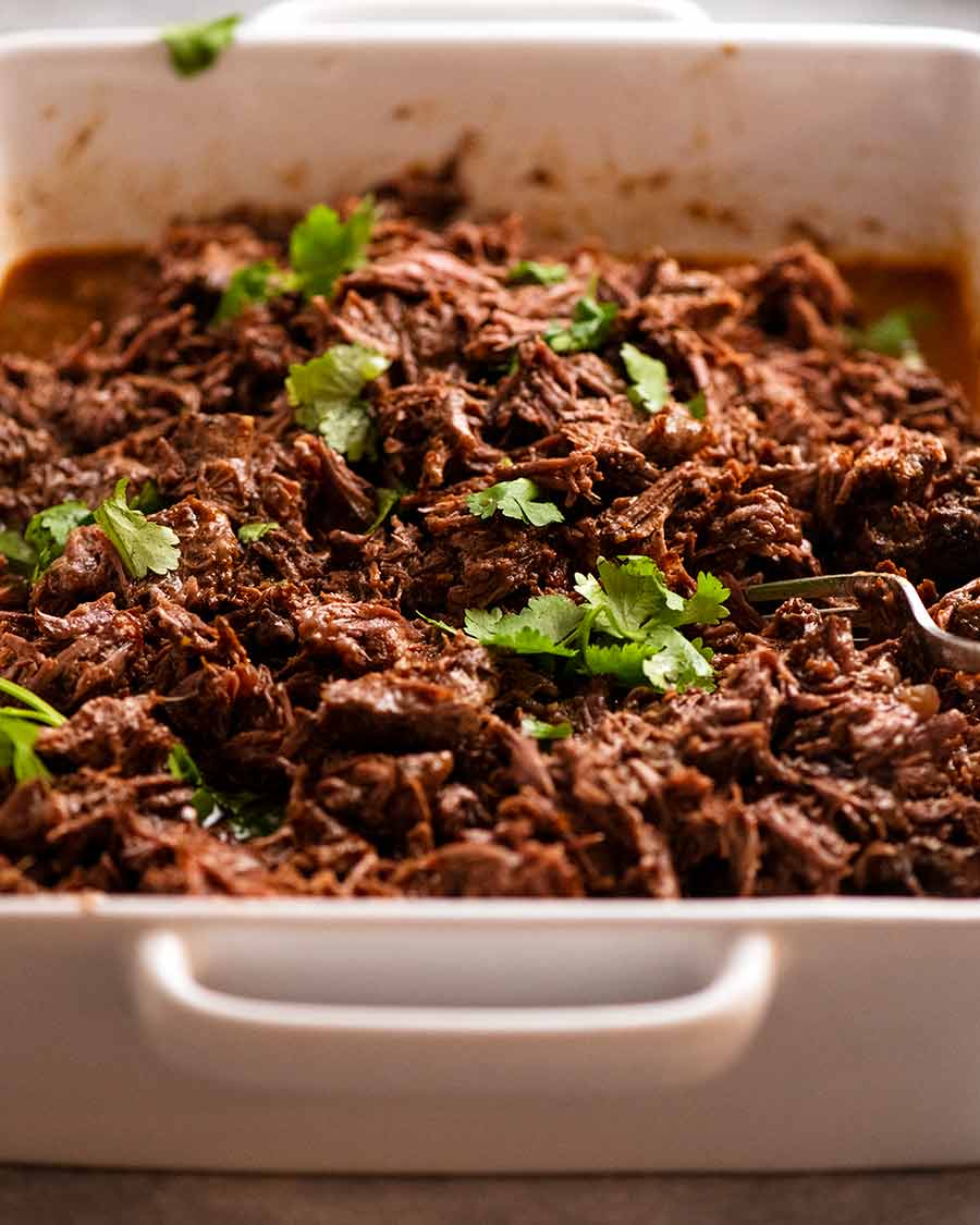 Casserole dish filled with Beef Barbacoa ready to use in tacos and burritos