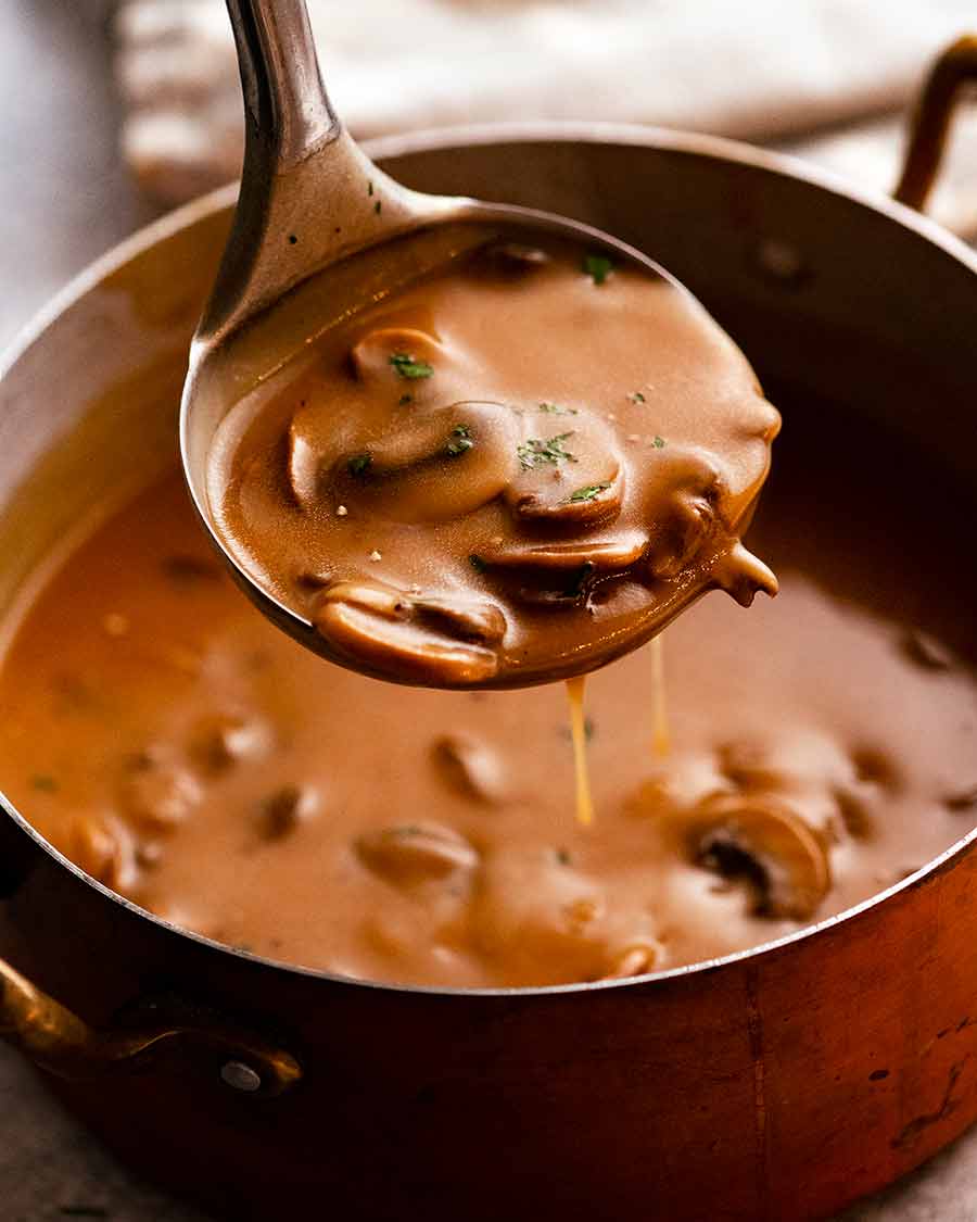 Ladle scooping up Mushroom Gravy from saucepan