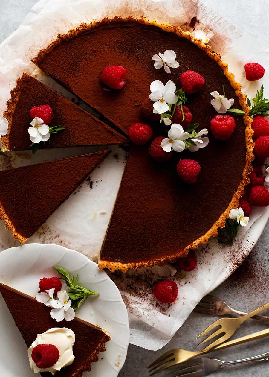 Chocolate Tart overhead photo decorated with raspberries and edible flowers