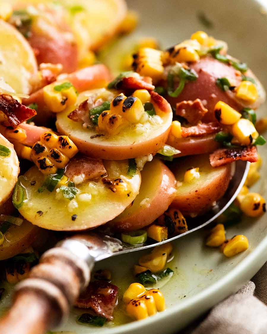 Close up photo of scooping up Red Potato Salad with Bacon and Corn