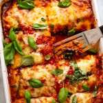 White baking dish with Eggplant Parmigiana, fresh out of the oven