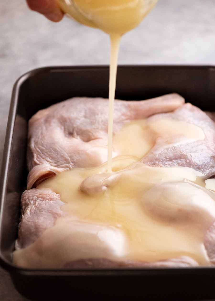 Pouring duck fat over duck legs to make Duck Confit