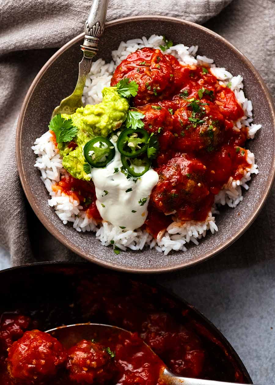 Overhead photo of Mexican Meatballs served with guacamole and sour cream over rice