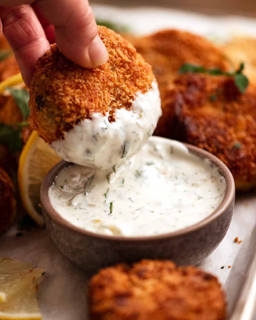 Dipping Fish cakes in tartare sauce