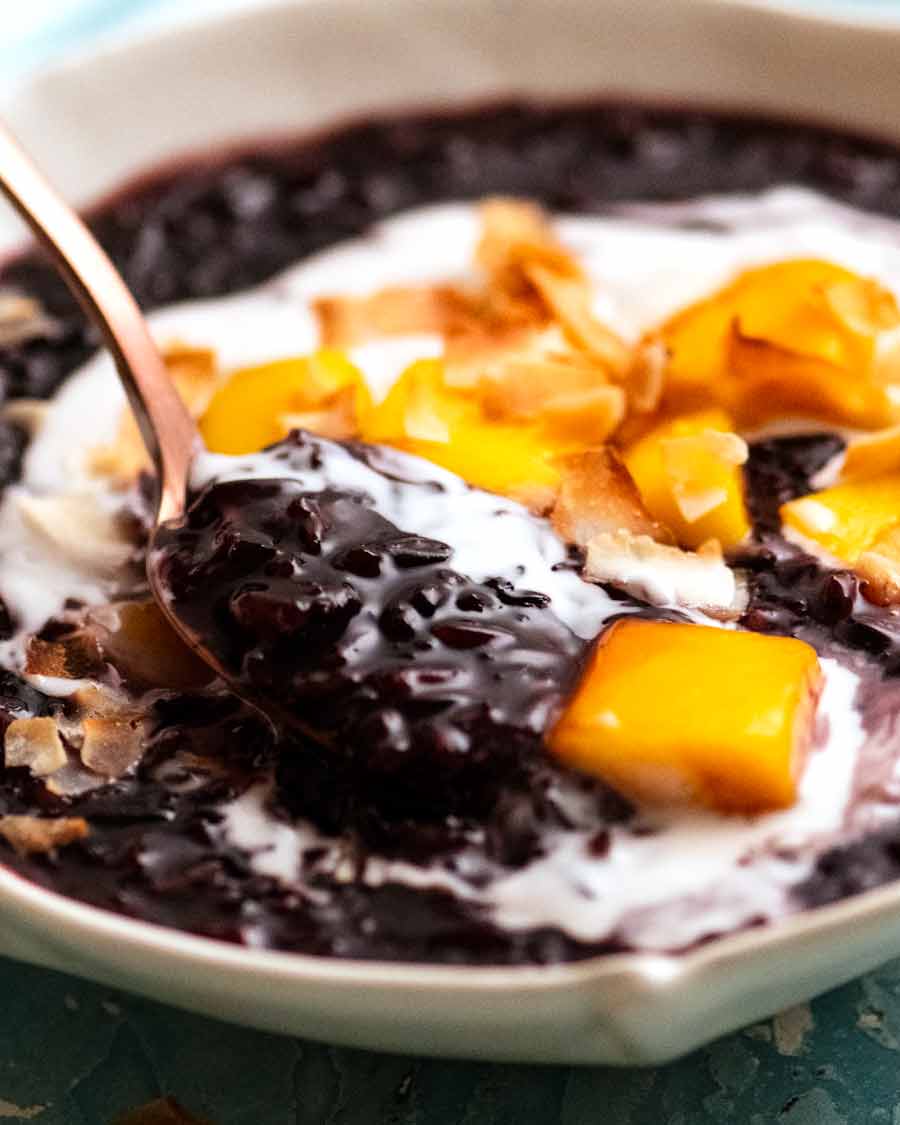 Close up of spoon scooping up Thai Black Sticky Rice Pudding