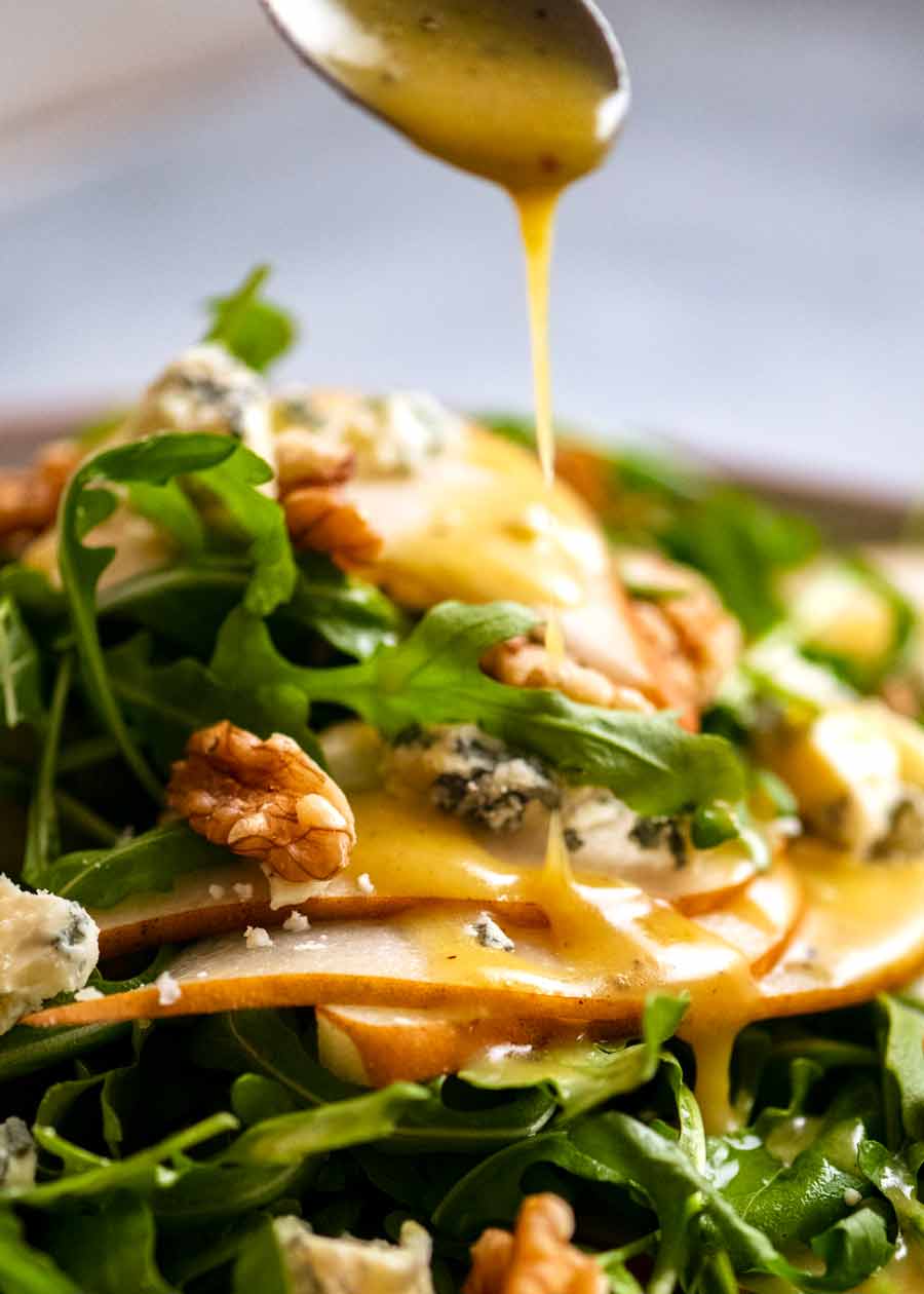 Drizzling Honey Mustard Dressing over Pear Salad with Blue Cheese and Rocket Arugula