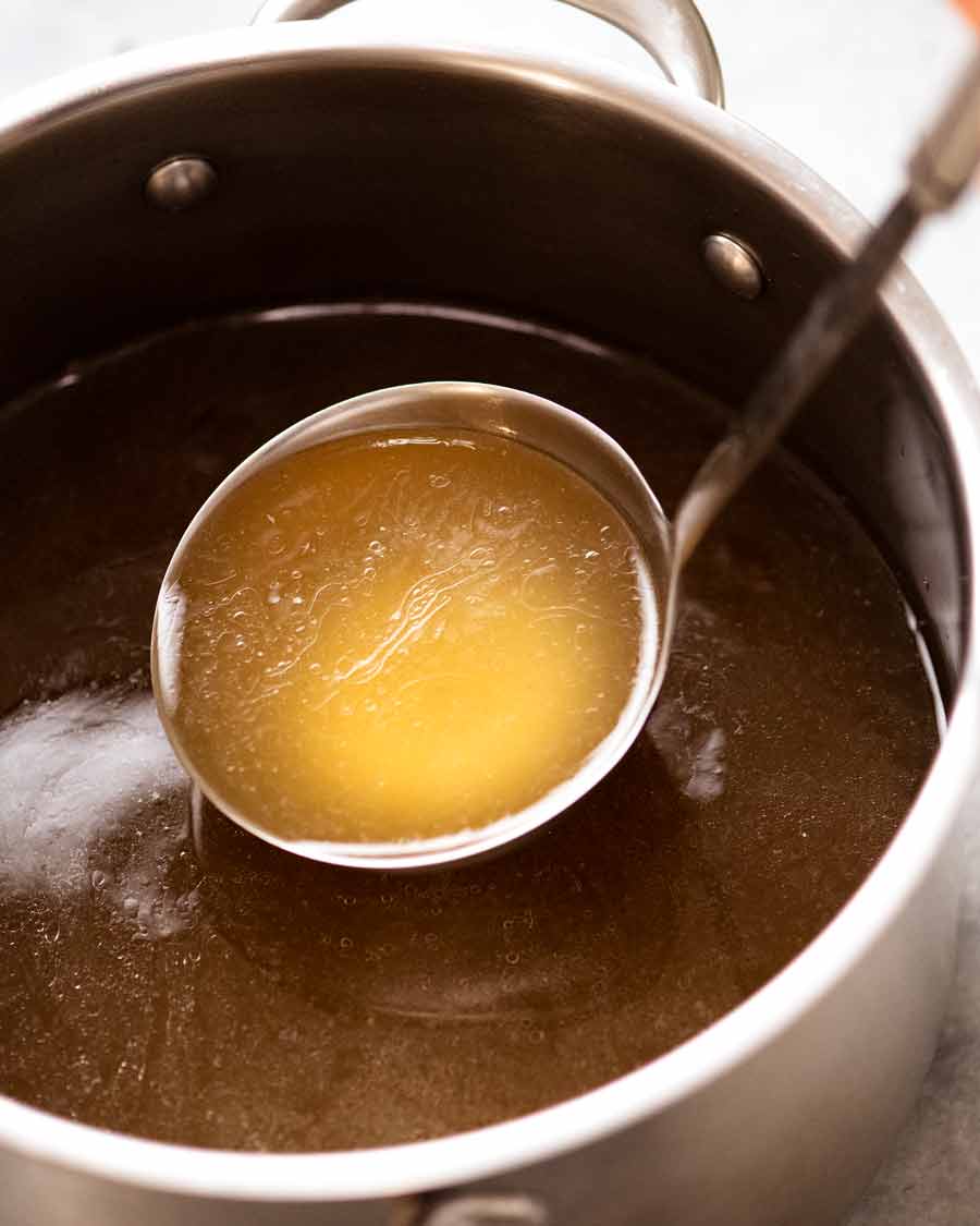 Ladle scooping up Homemade chicken stock