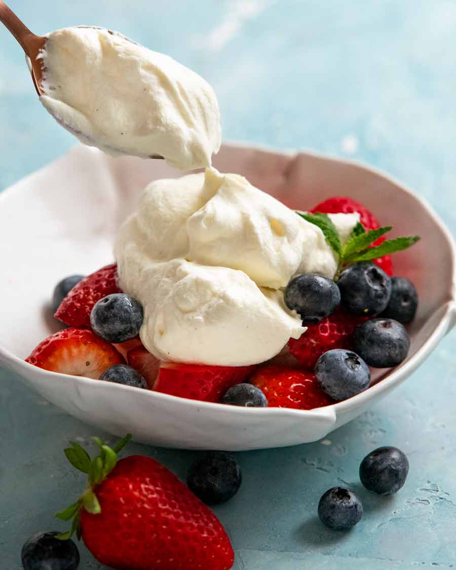 Chantilly cream - French whipped cream dollop on a bowl of fruit