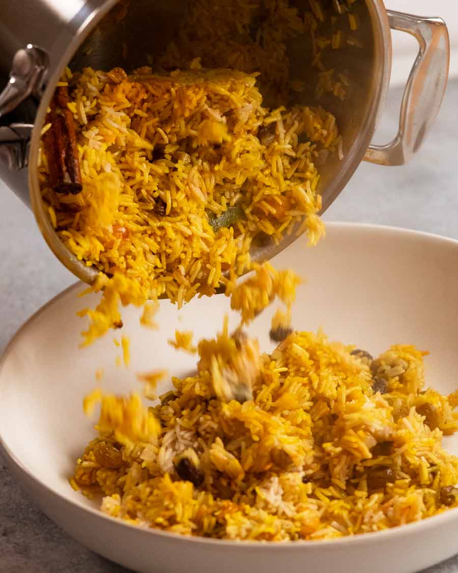Jewelled rice pilaf tumbling out of saucepan