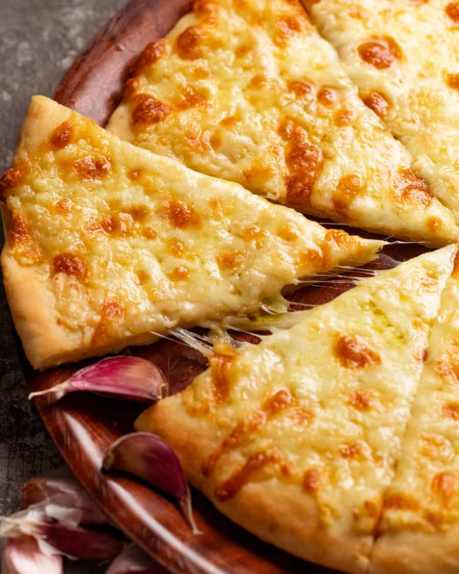Cerca de pizza de queso con ajo recién horneada