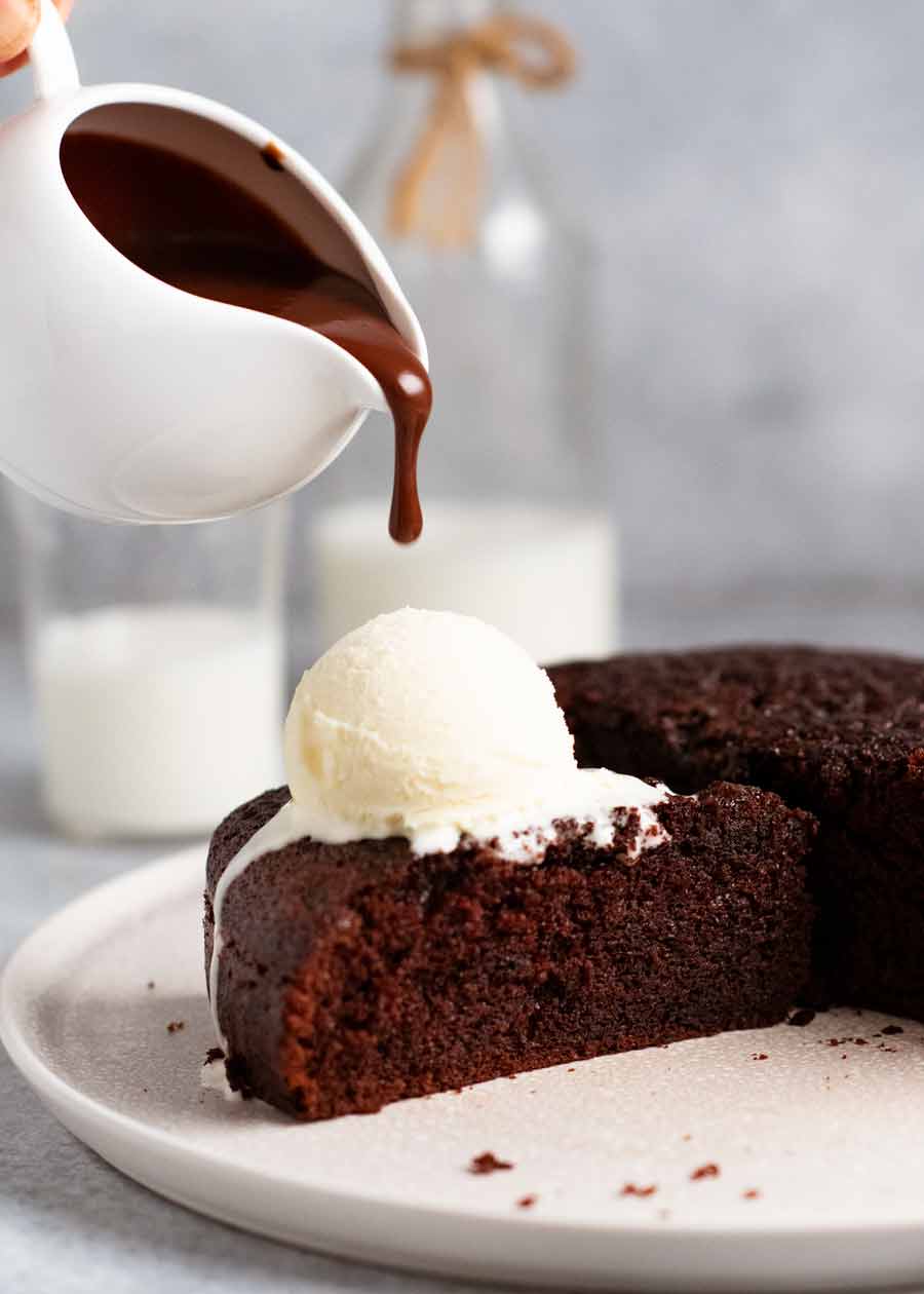 Pouring sauce over Hot chocolate fudge cake