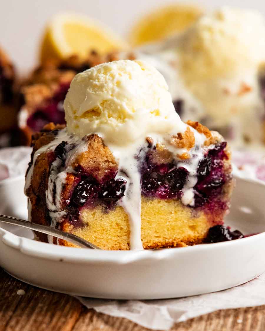 Slice of Bursting Blueberry Crumb Cake with vanilla ice cream